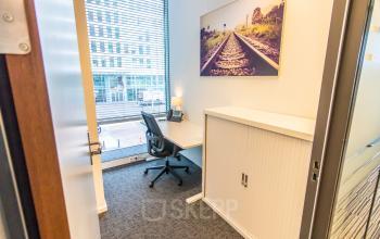 Kantoorruimte huren op Koningin Julianaplein 10 in Den Haag Centrum met bureau, stoel en kast. Grote ramen zorgen voor veel lichtinval. Perfect voor een productieve werkomgeving.