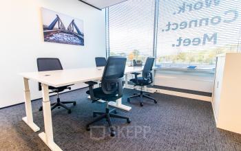 Kantoorruimte huren op Koningin Julianaplein 10 in Den Haag Centrum, met een open werkplek die voorzien is van bureaus, stoelen en modern interieur, ideaal voor zakelijke activiteiten.