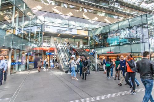 Winkelcentrum in Den Haag met meerdere mensen die door de ruimte lopen en winkelen.