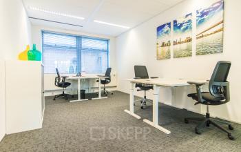 Kantoorruimte te huur op Parkstraat 83 in Den Haag Centrum, met moderne bureaus, comfortabele stoelen en kleurrijke decoratie. Grote ramen zorgen voor veel natuurlijk licht.