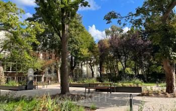 Exterieur van kantoorpand aan Zeestraat 70 in Den Haag Centrum met groene buitenruimte en banken, ideaal voor pauzes en ontspanning.