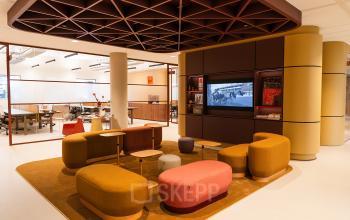 Moderne kantoorruimte op Zeestraat 70, Den Haag Centrum, met stijlvolle meubels en open indeling. Medewerkers zijn bezig met overleg en computerwerk, omgeven door een uitnodigende sfeer.