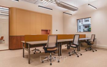 Moderne, lichte kantoorruimte huren op Zeestraat 70, Den Haag Centrum, met vier ergonomische bureaustoelen, strakke verlichting en een warme, rustige sfeer. Ideaal voor professioneel werken in een comfortabele omgeving.