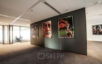 Moderne kantoorruimte op Kalvermarkt 53 te Den Haag Centrum, met kunst aan de muur en een uitgestrekte, goed verlichte werkvloer.