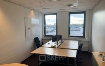 Kantoorruimte huren in kantoorpand op Platinaweg 10, Den Haag Escamp. Gezellige werkplek met twee bureaus en stoelen, grote ramen voor natuurlijk licht. Ideaal voor productief werken.