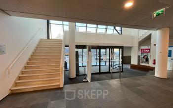 Entree van het kantoorpand aan de Platinaweg 10 in Den Haag Escamp, met een trap en glazen entree. Kantoorruimte huren in een moderne omgeving.