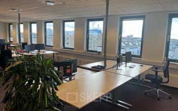 Lichte kantoorruimte met grote ramen en werkplekken aan de Platinaweg 10 in Den Haag Escamp, ideaal voor kantoorruimte huren met een modern interieur en uitzicht op de stad.