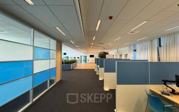 Moderne kantoorruimte aan Platinaweg 10, Den Haag Escamp met werkplekken, glazen wanden en blauwe accenten. Ideaal voor bedrijven die kantoorruimte zoeken. 