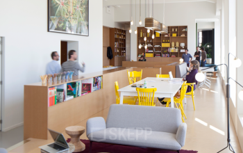 Moderne kantoorruimte in kantoorpand aan Zuid Hollandlaan 7, Den Haag Haagse Hout, met diverse werkplekken en ontspanningshoek.