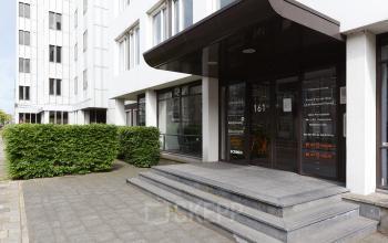Entree van het kantoorpand aan de Bezuidenhoutseweg 161, Den Haag Haagse Hout. De ingang heeft grote glazen ramen met zicht op de bedrijfsnamen binnen, geschikt om kantoorruimte te huren.