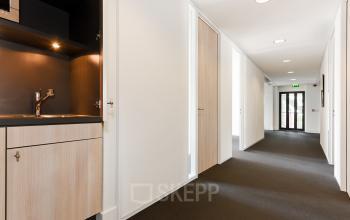 Kantoorruimte huren op Bezuidenhoutseweg 161 in Den Haag Haagse Hout met een moderne gang en pantry.