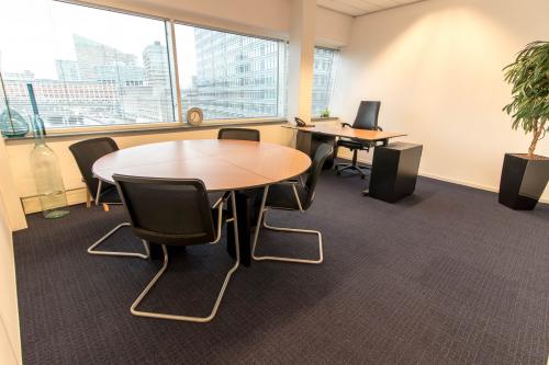 Modern ingerichte kantoorruimte op Jan Pietersz. Coenstraat 7, Den Haag Haagse Hout, met ronde vergadertafel en bureaus.