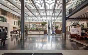 Modern interieur van kantoorgebouw op Prinses Margrietplantsoen 25, Den Haag Haagse Hout, met glanzende vloeren en ruime lobby met personeelsactiviteit.