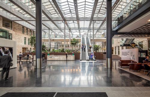 Modern interieur van kantoorgebouw op Prinses Margrietplantsoen 25, Den Haag Haagse Hout, met glanzende vloeren en ruime lobby met personeelsactiviteit.