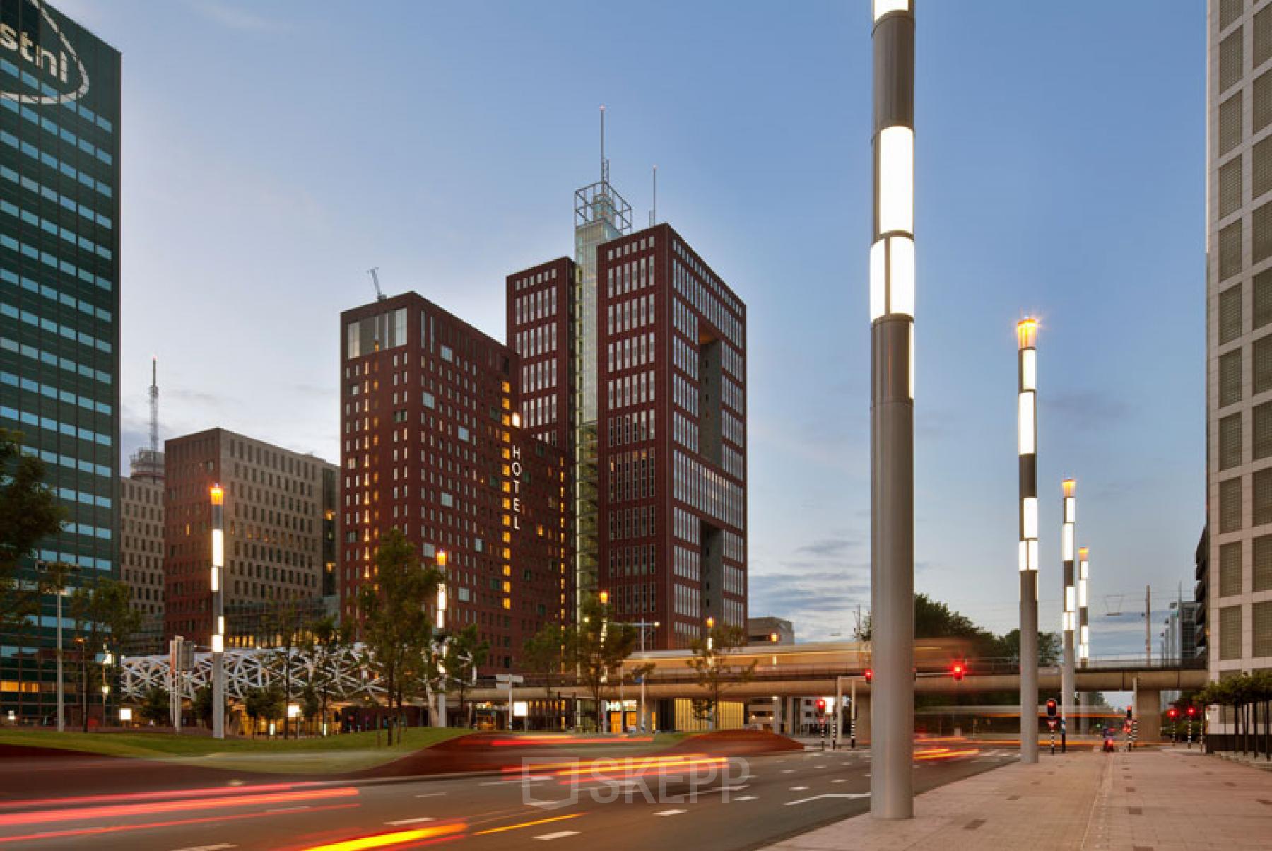 Buitenzicht op het kantoorpand aan Prinses Margrietplantsoen 25, Den Haag Haagse Hout, omgeven door moderne architectuur en wegverlichting. Ideale locatie voor kantoorruimte huren.