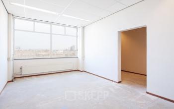 Leeg kantoorpand te huur op Calandstraat 1-35, Den Haag Laak. Ruime kamer met groot raam en veel natuurlijk licht, ideaal voor kantooractiviteiten.