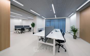 Moderne kantoorruimte met strakke bureaus en sfeervolle verlichting aan de Waldorpstraat 5 in Den Haag.