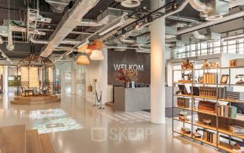 Moderne ontvangsthal in kantoorpand aan de Oude Middenweg 3-19 in Den Haag met stijlvolle verlichting en welkomstbalie.