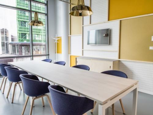 Moderne vergaderruimte in kantoorpand aan de Oude Middenweg 3-19 in Den Haag, uitgerust met een lange tafel en comfortabele stoelen.