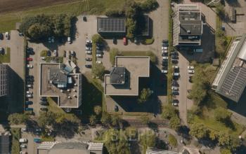 Luchtfoto van kantoorpand op Keulenstraat 9 in Deventer, omgeven door parkeerterreinen en groen. Ideale locatie voor kantoorruimte huren met voldoende parkeermogelijkheden.