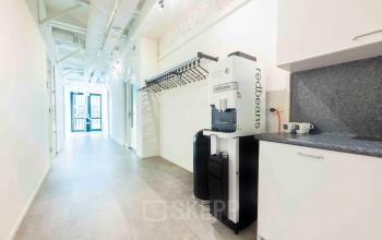 Kantoorruimte huren in Deventer op Keulenstraat 9 met moderne faciliteiten, helder verlichte gang en koffiemachine. Geschikt voor diverse zakelijke activiteiten binnen een professioneel kantoorpand.