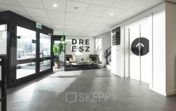Ingang van het kantoorpand op Keulenstraat 9, Deventer, met modern design en zitgelegenheid. Ideaal voor wie kantoorruimte wil huren in een eigentijdse omgeving.
