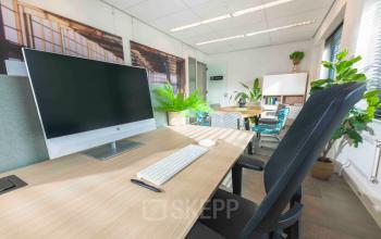 Zakelijke kantoorruimte huren op Keulenstraat 9, Deventer, met moderne werkplekken, computerschermen en groen decor.