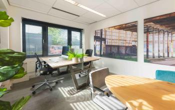 Lichte kantoorruimte op Keulenstraat 9, Deventer met moderne bureaus en stoelen, grote ramen en wanddecoratie. Ideaal voor kantoorruimte huren.
