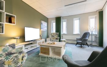 De kantoorruimte aan Keulenstraat 12 in Deventer beschikt over comfortabele zitgedeeltes, een groot tv-scherm en stijlvolle decoratie.