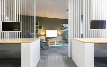 Moderne kantoorruimte huren op de Keulenstraat 12 in Deventer, kantoor met werkplekken voorzien van computers en licht groene muren.