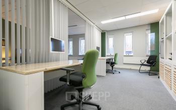 Goed verlichte kantoorruimte huren op Keulenstraat 12, Deventer, voorzien van werkplekken met groene bureaustoelen en computers, geschikt voor zakelijke activiteiten.