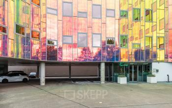 Kleurrijk en modern exterieur van het kantoorgebouw op Zutphenseweg 29 in Deventer, ideaal voor kantoorruimte huren. Het ontwerp springt direct in het oog met zijn levendige gevel en ruime parkeerplekken.