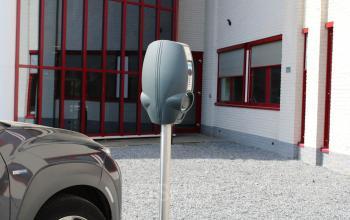 Oplaadpunt voor elektrische voertuigen bij een kantoorpand op Keulenstraat 1, Deventer. Bakstenen gevel met rode omlijsting. Ideaal voor kantoren die duurzaamheid belangrijk vinden bij kantoorruimte huren.