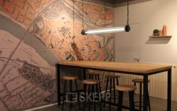 Kantoorruimte huren aan Keulenstraat 12 in Deventer met hoge tafels en themawanddecoratie. Ideaal voor samenwerking in een creatieve sfeer.