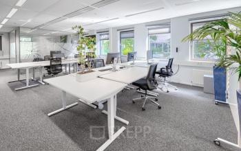 Lichte kantoorruimte met moderne bureaus en ergonomische stoelen, geschikt voor dynamisch werken. Grote ramen zorgen voor natuurlijke lichtinval. Optimaal voor wie een kantoorpand in Diemen wil huren.