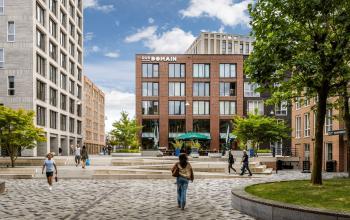 Exterieur van kantoorpand op Diemermere 11-19 in Diemen met moderne architectuur, omringd door plein met mensen die wandelen en ontspannen. Ideale plek voor kantoorruimte huren.