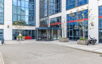 Ingang van een modern kantoorpand op Diemermere 11-19 in Diemen, met glazen gevel en fietsstalling. Overweeg hier kantoorruimte te huren.