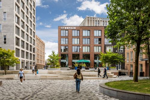 Exterieur van kantoorpand op Diemermere 11-19 in Diemen met moderne architectuur, omringd door plein met mensen die wandelen en ontspannen. Ideale plek voor kantoorruimte huren.