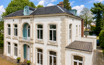 Gevel van een statig kantoorpand aan de Dorpsstraat 77 in Doorn met klassieke details en grote ramen, ideaal voor het huren van een kantoorruimte.