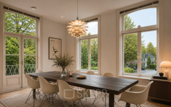 Ruime vergaderruimte met houten tafel en designstoelen, omringd door grote ramen die veel natuurlijk licht binnenlaten. Ideaal voor kantoorruimte huren op Dorpsstraat 77, Doorn.