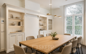 Stijlvolle vergaderruimte met houten tafel, comfortabele stoelen en ingebouwde kasten in kantoorpand Dorpsstraat 77, Doorn.