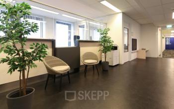 Kantoorpand aan Van Knobelsdorffplein 14, Drachten, met lichte open werkruimte, stoelen en planten bij een balie. Ideale locatie om kantoorruimte te huren.