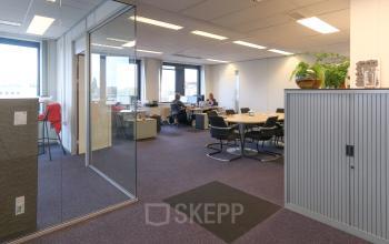 Licht kantoorpand op Van Knobelsdorffplein 14, Drachten met ruime werkplekken en enkele mensen die geconcentreerd werken. De ruimte biedt mogelijkheden voor kantoorruimte huren met moderne voorzieningen.