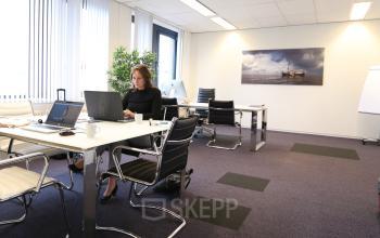 Kantoorruimte op Van Knobelsdorffplein 14, Drachten, met personen bezig met zakelijke activiteiten aan bureaus, moderne inrichting met stoelen en laptops.