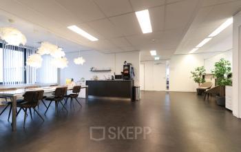 Interieur van een kantoorpand aan Van Knobelsdorffplein 14, Drachten met een gemeubileerde ruimte voor zakelijke activiteiten en een koffieautomaat, ideaal voor kantoorruimte huren in een functionele omgeving.