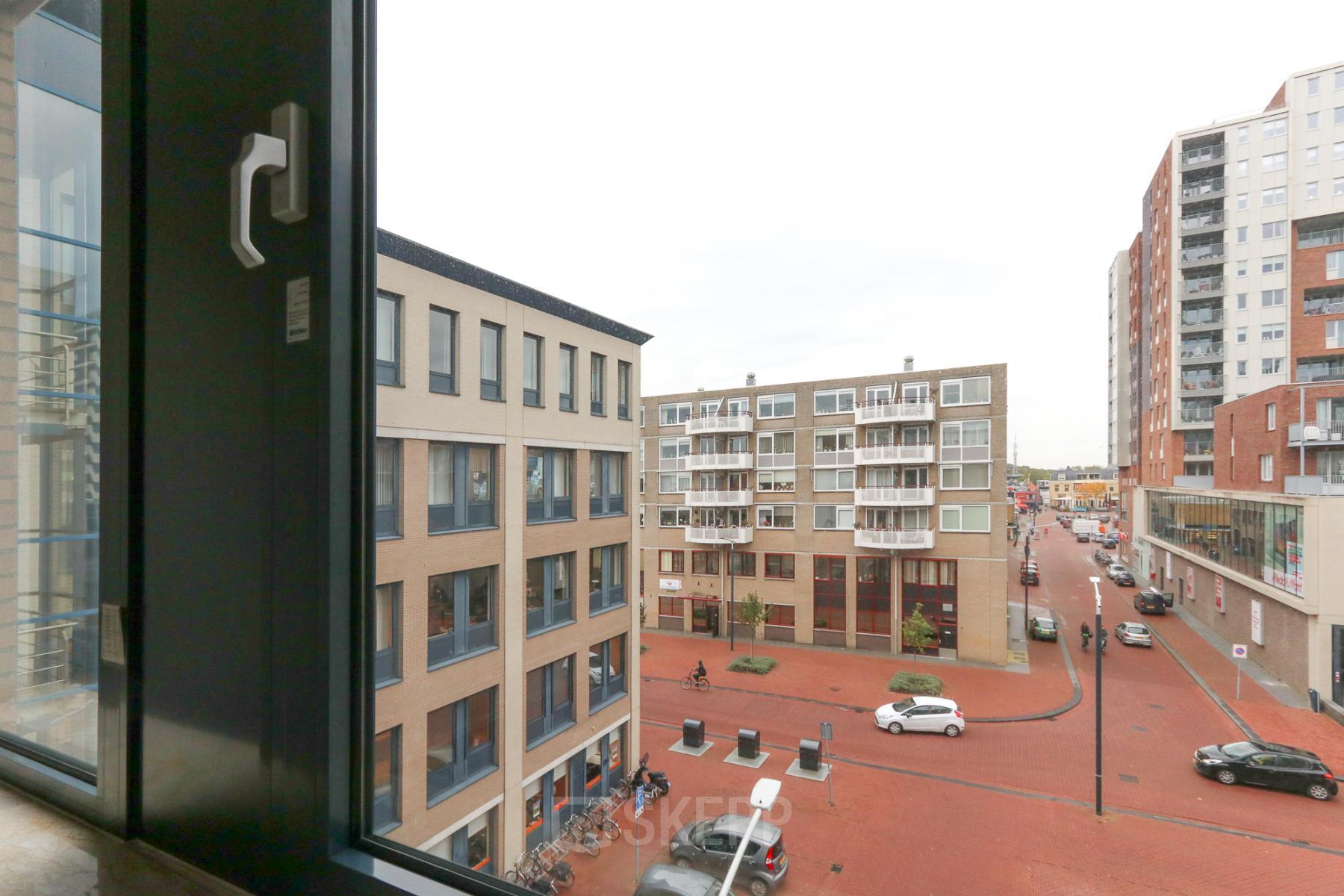 Exterieur van het kantoorpand op Van Knobelsdorffplein 14 in Drachten, met modern design en uitzicht op het plein waaronder enkele geparkeerde auto's.