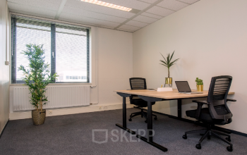 Kantoorruimte huren op Galvanistraat 7 in Ede, met twee bureaus, comfortabele stoelen, laptops en planten, geschikt voor productief werk.