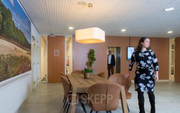 Kantoorruimte huren in modern kantoorpand aan Galvanistraat 7, Ede, met een vergadertafel en medewerkers in zakelijke bespreking.