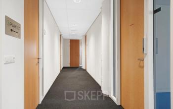 Heldere gang in kantoorpand aan de Celsiusstraat 34, Ede, met meerdere deuren naar kantoorruimte huren.
