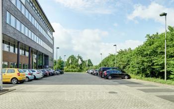Buitenaanzicht van een modern kantoorpand op Celsiusstraat 34 in Ede met een ruime parkeerplaats. Ideaal voor wie kantoorruimte wil huren in een groene omgeving.